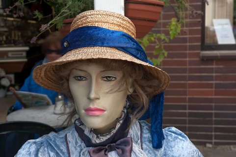 Figure wearing straw hat and nostalgic dress in front of a café, Görllitz, Upper Lusatia, Saxony,