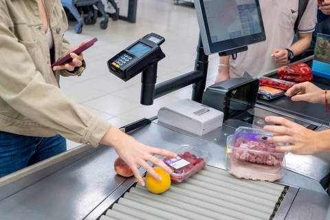 Customers are scanning groceries and selecting items at a self service supermarket checkout