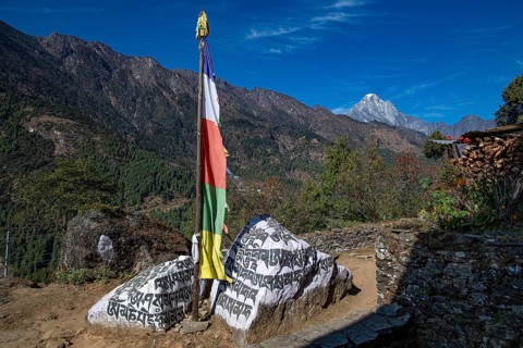 Buddhist prayer flag and holy mantras on manistones on the way to Mount Everest, Solu Khumbu,