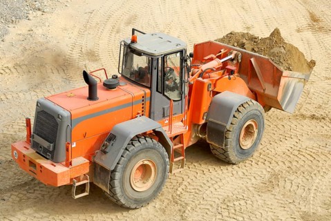 A modern, heavy wheel loader, excavator, shovel excavator transports bulk material in a gravel pit,