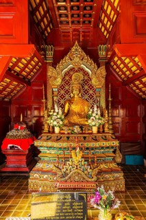Gilded Buddha statue in a public prayer hall in the Wat Phra Singh Buddhist temple complex, Chiang