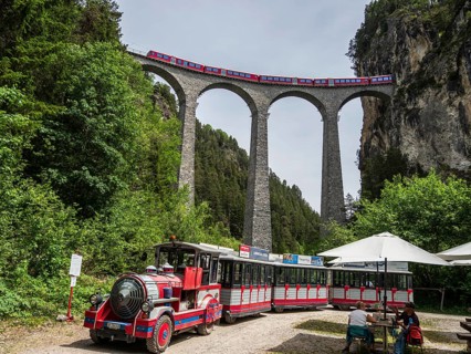 Tourist sightseeing train stops at the Landwasser viaduct, real train of the Rhaetian railroad line