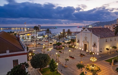 The Africa square illuminated at noon with Our Lady of Africa church and the port of Ceuta, Spain,