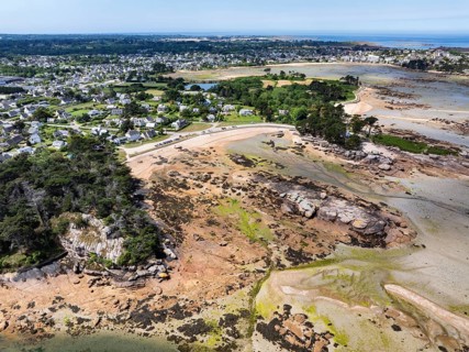 Aerial view of the Plage de Tourony beach at low tide, behind it the village of Tourony on the