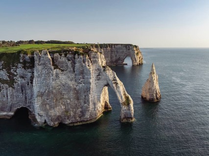 Aerial view of the Porte d'Aval rock formation in the evening sun, well-known sights on the chalk