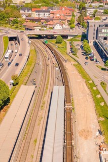 Aerial view of a train station with several train tracks and roads, surrounded by buildings and