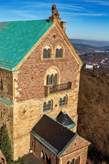 Detailed view of the castle with several windows and balconies, surrounded by countryside, The