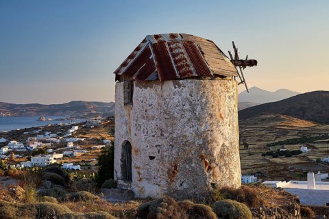 Windmill above Chorio on Mount Xaplovouni, abandoned mill on a hill with sea view at sunset, main