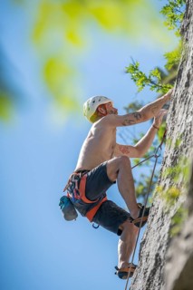 Man climbing in a difficult rock climbing tour in the La Gola climbing area, Sarca Valley, Lake