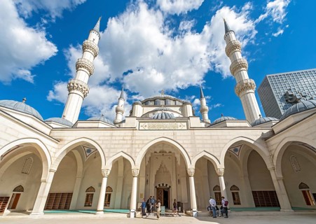 A wide-angle view of the courtyard, arches, and towering minarets of the Namazgah Mosque under a