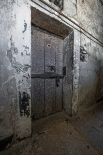 Massive aged iron door in a rough stone wall, Kilmainham Gaol Prison, Dublin, Ireland