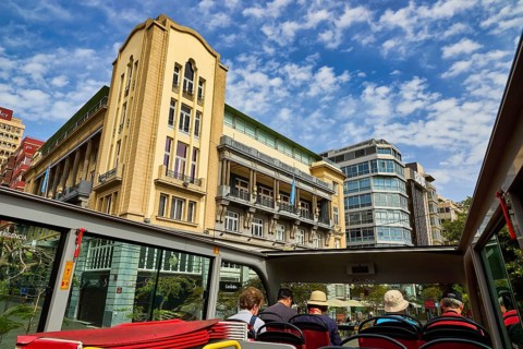 City view with tourists in an open bus and diverse architecture, capital city, Santa Cruz de