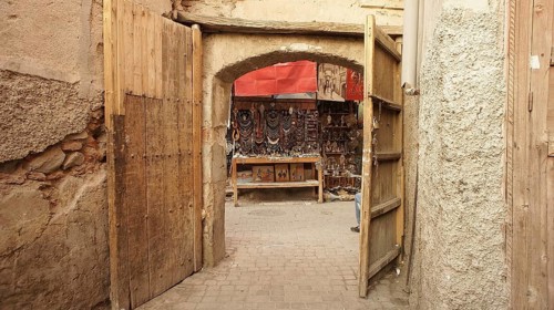 Open wooden gates lead to a jewelry stand in a narrow alley in the old town, traditional
