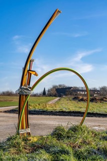 Fibre optic connection, empty conduits protrude from the ground along a dirt track, into which the