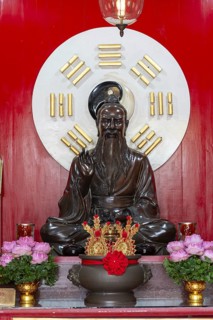A dark, intricately crafted statue of Laozi (Lao Tzu), the legendary philosopher and founder of