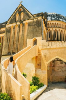 Caucasian Woman tourist wear white dress explores visit historic Christ Church Anglican Cathedral