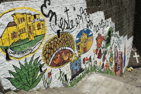 Colourful wall painting, graffiti on a staircase showing buildings and plants with lettering,