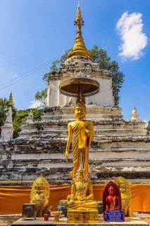 Gilded Buddha statues, the white, multi-tiered Chari temple tower, stupa, Buddhist temple complex