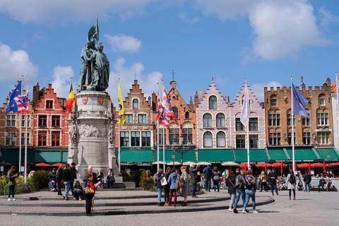 Market square Grote Markt with Jan Breydel and Pieter de Coninck monument and guild houses, Bruges,