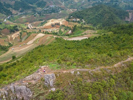 Aerial view of a woman with a pink rucksack walking along The Dinosaur Backbone (S?ng Lung Kh?ng
