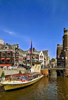 An excursion boat with tourists in a canal in the city of Amsterdam, the Netherlands, Holland