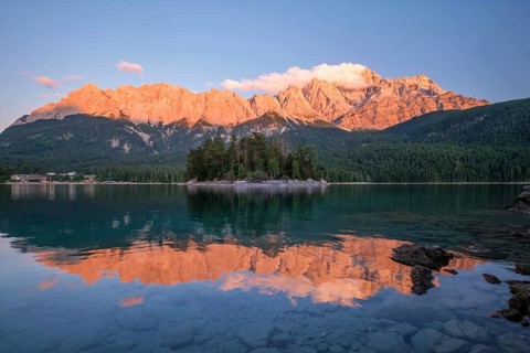Beautiful sunset glow over the Maximiliansinsel island at Eibsee lake with Zugspitze mountain peaks