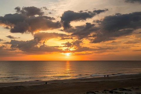 View of the beach from a dune, sunset and evening sky behind it, walkers, Houvig beach, North Sea,