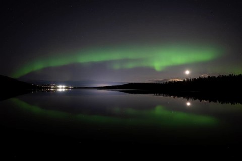 The Northern Lights (Aurora borealis) reflected in a forest lake, Gällivare, Norrbotten, Lapland,