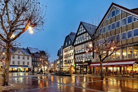 Street scene with illuminated half-timbered houses and winter decoration at dusk, view of the city