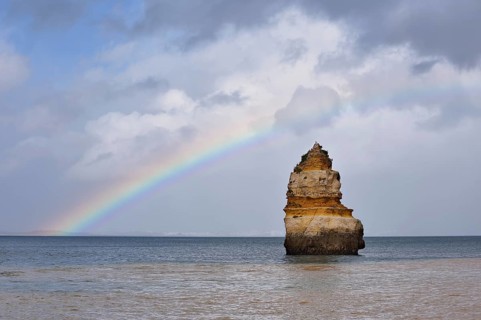Rock formation in the ocean with rainbow, Praia do Camilo, Lagos, Algarve, Portugal