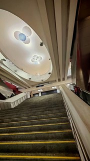 Modern interior staircase of a subway station with distinctive ceiling light and upward view,