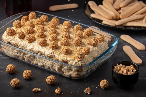 Ready tiramisu with nut balls surrounded by bisque and nuts