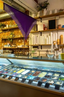 Modern ice cream parlor showcasing a wide selection of frozen dessert gelato flavors, with cups and