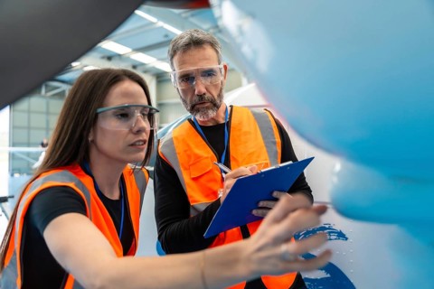 Aviation engineers conducting a thorough safety inspection and checklist review on an airplane in a