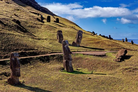 Hill with several Moai statues and a view of the sea under a blue sky, The Moai Statues on Easter