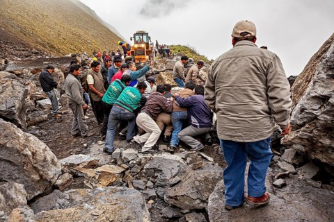 People work together on a foggy mountain road, help move a big rock, rockslide on the pass road