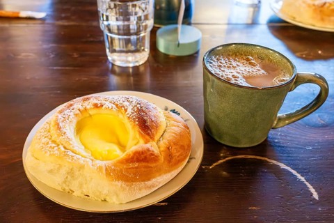 Cinnamon roll filled with vanilla cream and a cup of coffee, Henningsvaer, Lofoten, Norway