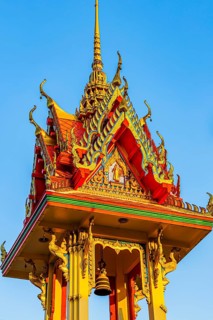 Artfully decorated bell tower with golden ornaments and delicate roof architecture, Koh Kret river