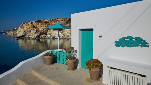 Terrace with green railing and sea view on rocky coast, Syrmata, boat garages, boathouse,