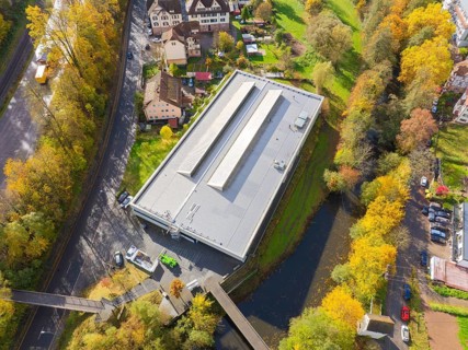 Commercial building in the midst of autumn landscape with river and bridges, surrounded by