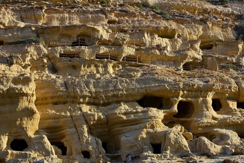 Neolithic caves, former hippie paradise, close-up of an eroded rock wall with several small caves,