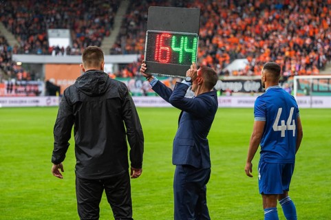 Man shows players substitution during football match in Lubin, Poland