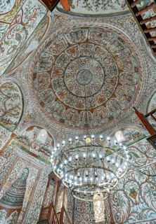 The beautifully restored interior of Et'hem Bey Mosque featuring a large chandelier under the dome,