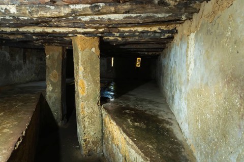 Interior of an underground slave holding chamber in Stone Town, Zanzibar. Low-angle view of cramped