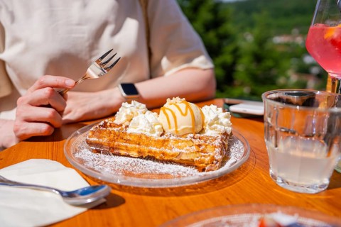Waffles with ice cream and cream served on a wooden outdoor table, Calw, Black Forest, Germany