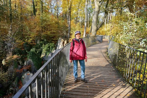 Woman on a footbridge in autumn, Felsenmeer, Hemer, North Rhine-Westphalia, Germany