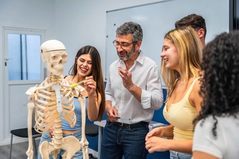 Young diverse students and an adult teacher engaging in a biology lesson, discussing the human
