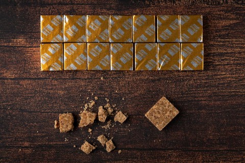 Soup cubes with and without packaging on a wooden table