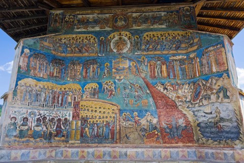 Detailed frescoes with saints and iconic scenes on a church wall, exterior view, Saint George