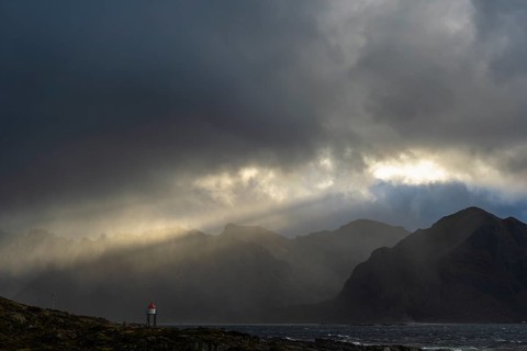 Sunbeams over coastal landscape and sea, Lofoten, Nordland, Norway, September 2020